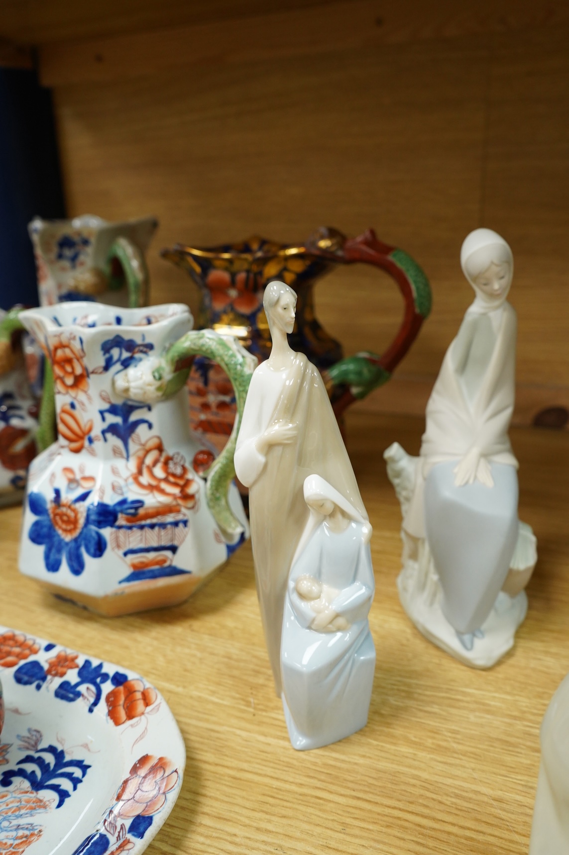 A group of Lladro figures: Tramp with violin, Bust of Mary Magdalene, Holy family, Girl with child, Young Shepherds, Girl with basket, girl with jug